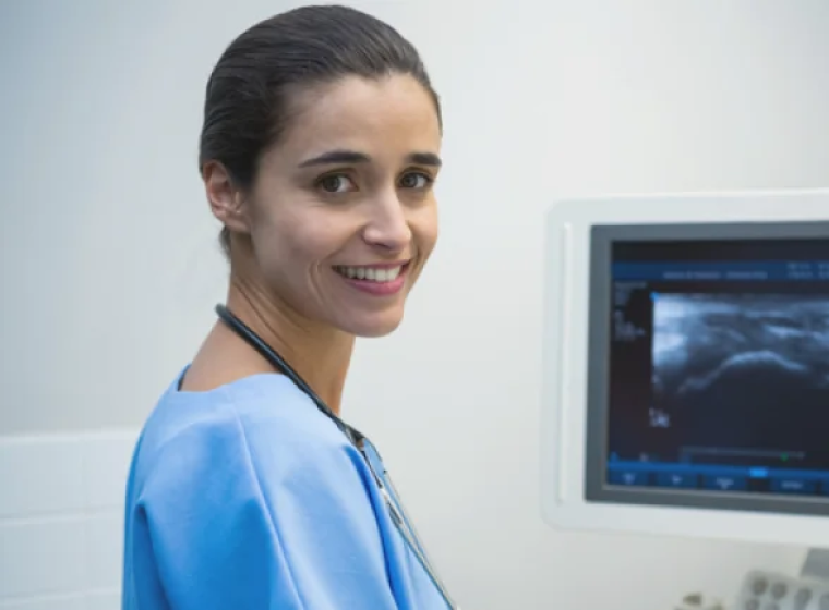 A cardiac sonographer next to computer
