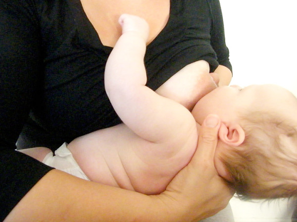 Breastfeeding parent holding baby in the cross-cradle position
